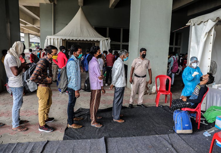 Queue of men waiting for coronavirus test in New Delhi.