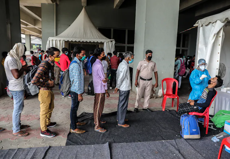 Queue of men waiting for coronavirus test in New Delhi.
