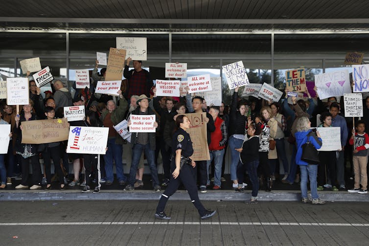 Protesters at the San Francisco airport hold signs reading 'refugees are welcome here' and 'build bridges not walls.'