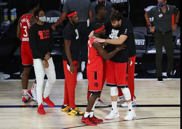 Toronto Raptors guard Terence Davis (0) reacts with center Marc Gasol (33) and other players convene at the side of the court.