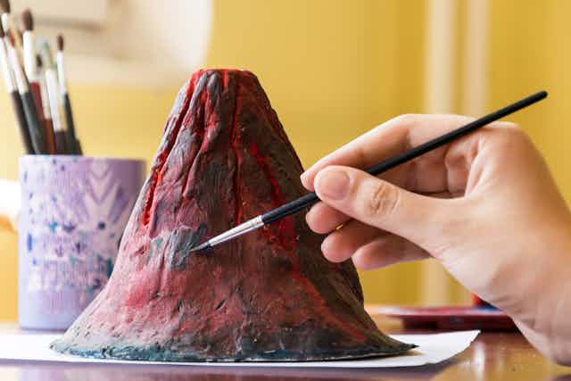 A clay volcano being painted