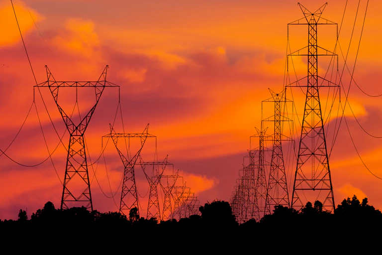 Electricity towers against a sunset.