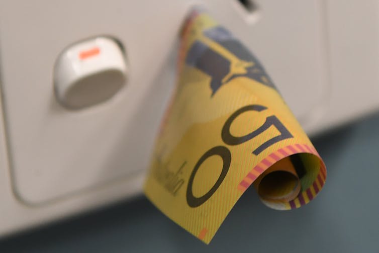 A $50 note sticking out of a power socket.