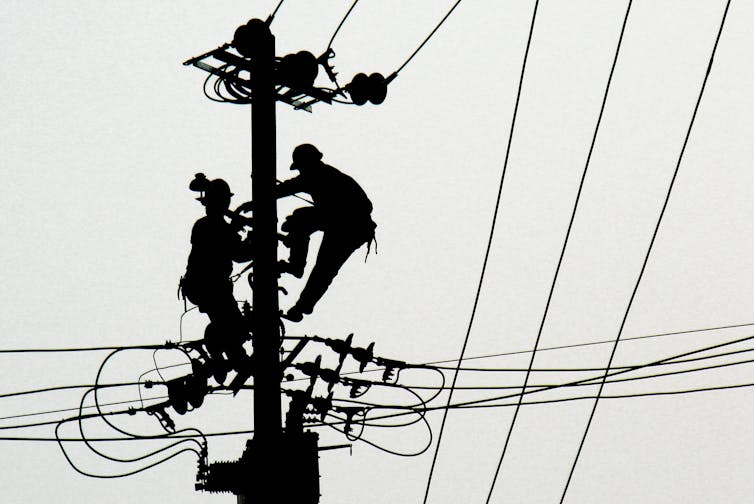 Workers perform maintenance on power lines.