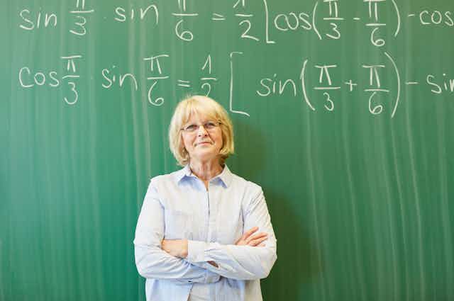 Profesora veterana ante una pizarra con fórmulas matemáticas