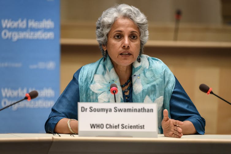 World Health Organization chief scientist Soumya Swaminathan sits in front of microphones