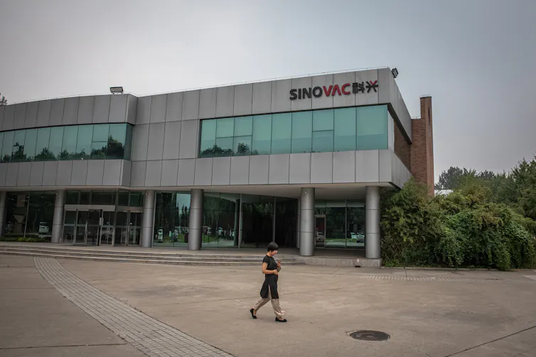 Woman walking past the Sinovac headquarters in Beijing.