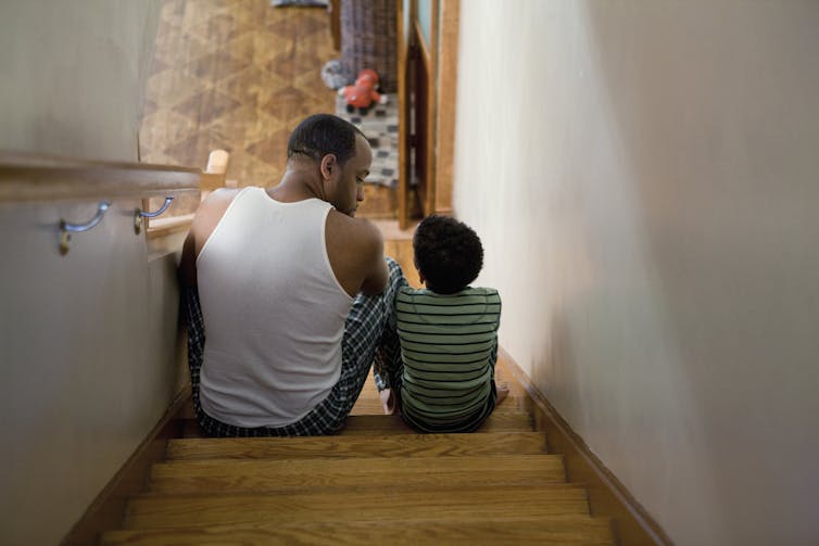 A man and a boy sitting on the stairs.