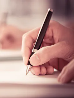 A hand holding a pen.