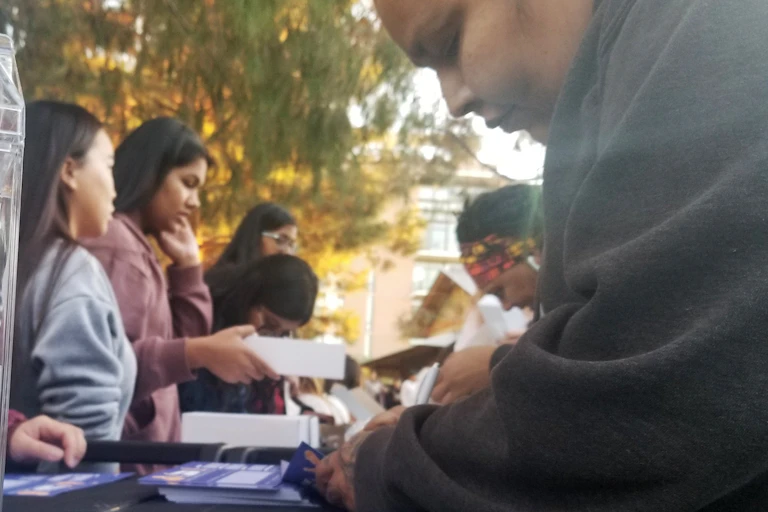 A woman fills out a form at a table