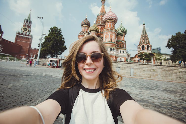 Young woman taking a selfie against Russian skyline.
