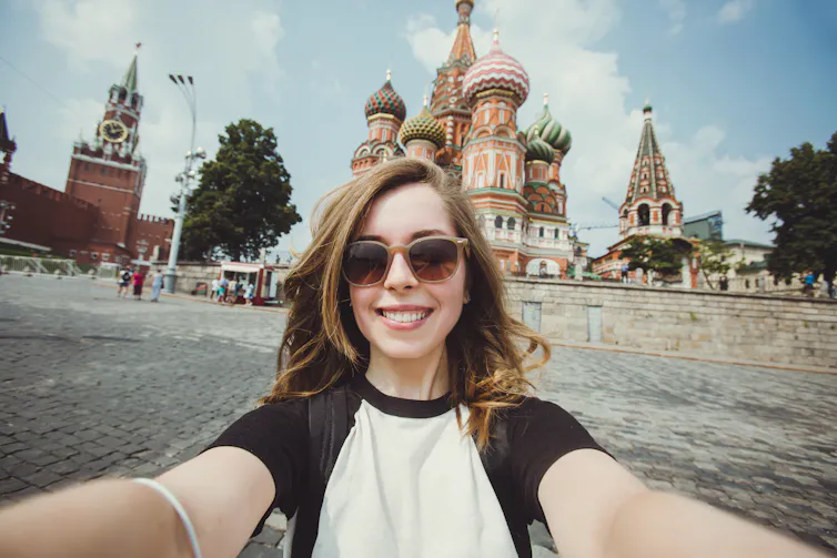Young woman taking a selfie against Russian skyline.
