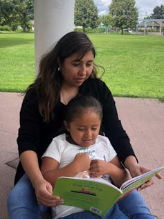 A mother reading to her daughter.
