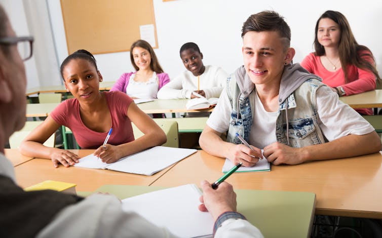 Students smiling at something a teacher has said.