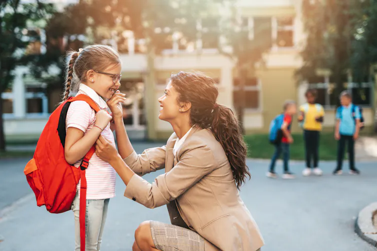 Mother and daughter outside school
