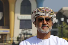 A man wearing a head scarf and sunglasses.