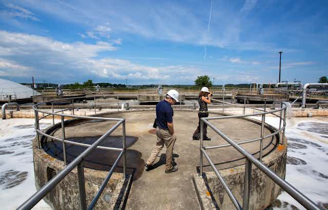 two people overlook an aeration system at a wastewater treatment plant