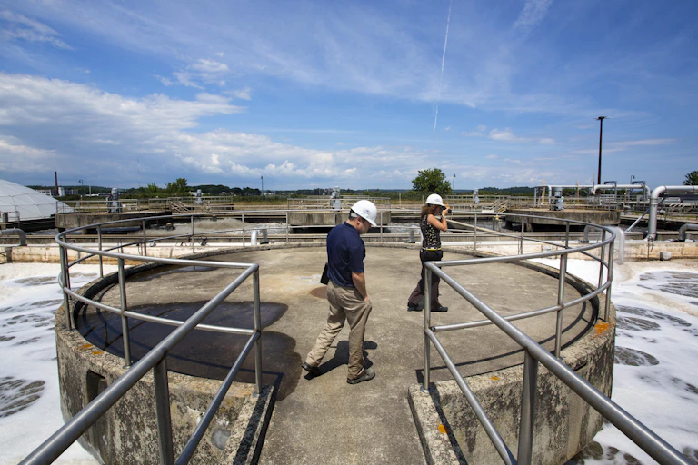 two people overlook an aeration system at a wastewater treatment plant
