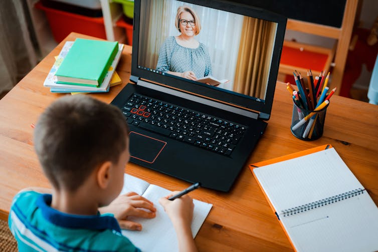 Boy watching virtual class on laptop.