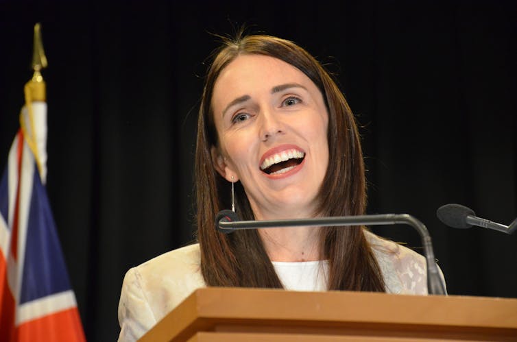 Jacinda Ardern behind a microphone.