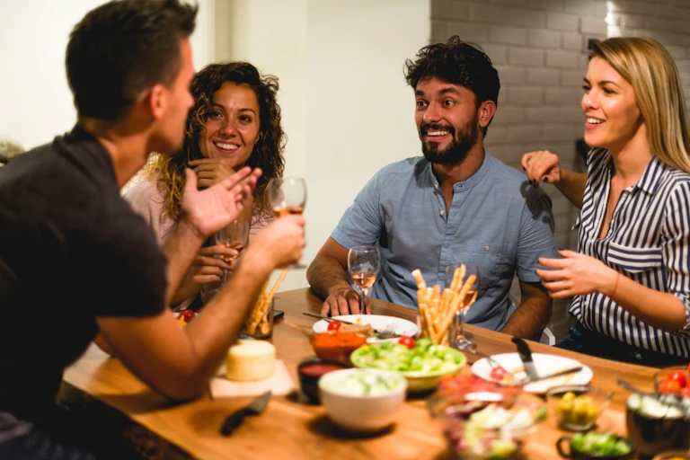A group of friends eating dinner together at home