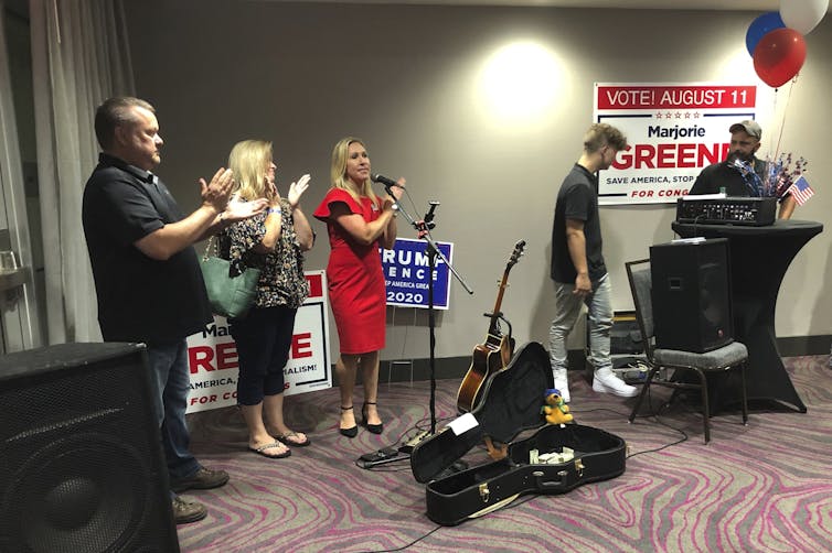 Marjorie Taylor Greene claps with her supporters at a watch party in Georgia on the night of her congressional runoff.