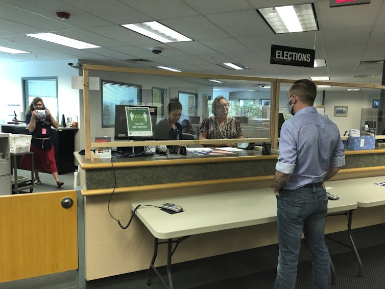 A man stands at a counter at a government office.