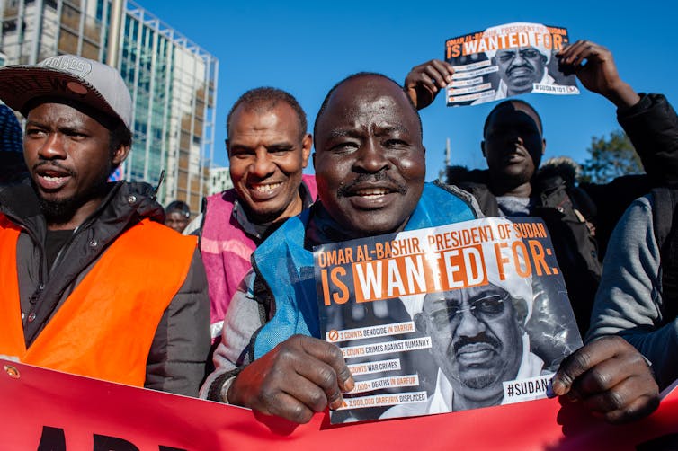 Protesters hold sings saying al-Bashir is 'wanted'