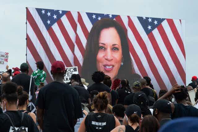 Kamala Harris speaking via a screen to demonstrators at the  protest against racism and police brutality.