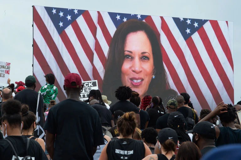 Kamala Harris speaking via a screen to demonstrators at the protest against racism and police brutality.