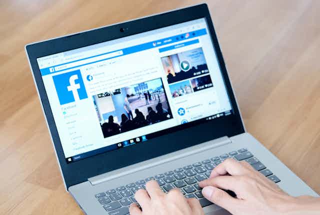 A laptop displays the Facebook platform.