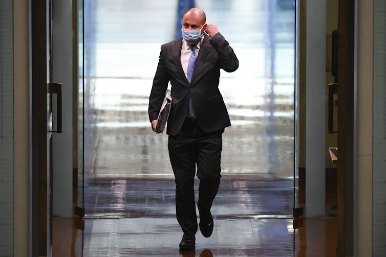 Treasurer Josh Frydenberg walks down a hall.