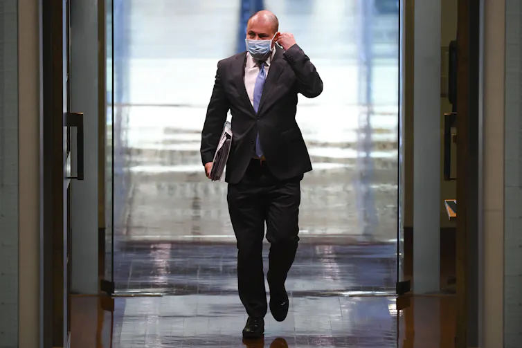 Treasurer Josh Frydenberg walks down a hall.