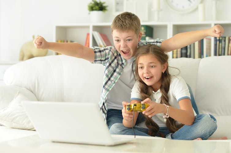 Boy and girl playing with a video game controller.