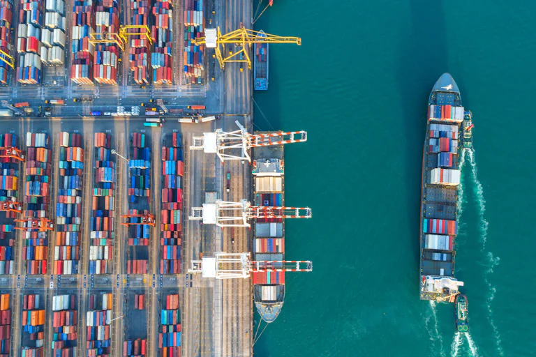 Shipping terminal with containers and cargo ships.