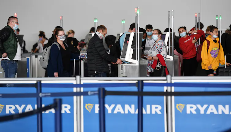 People wearing masks at a Ryanair desk.