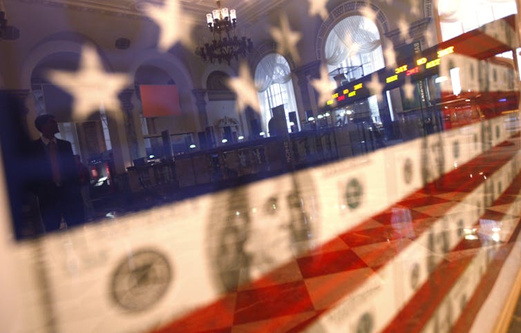 Picture of US flag with stock listings reflected in it