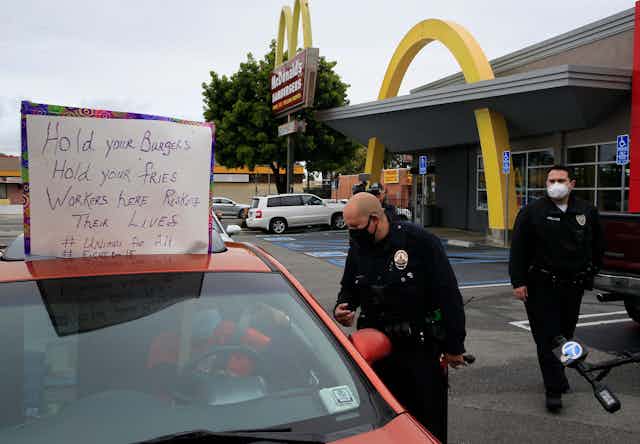 Los Angeles Police officers ask protesters in their vehicles to move along the drive-thru outside a McDonald's restaurant in the Crenshaw district of Los Angeles on April 6.