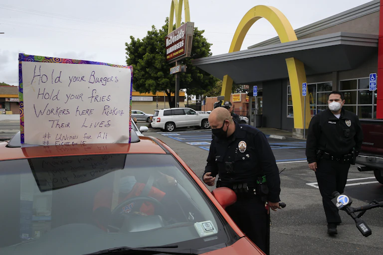 Los Angeles Police officers ask protesters in their vehicles to move along the drive-thru outside a McDonald's restaurant in the Crenshaw district of Los Angeles on April 6.