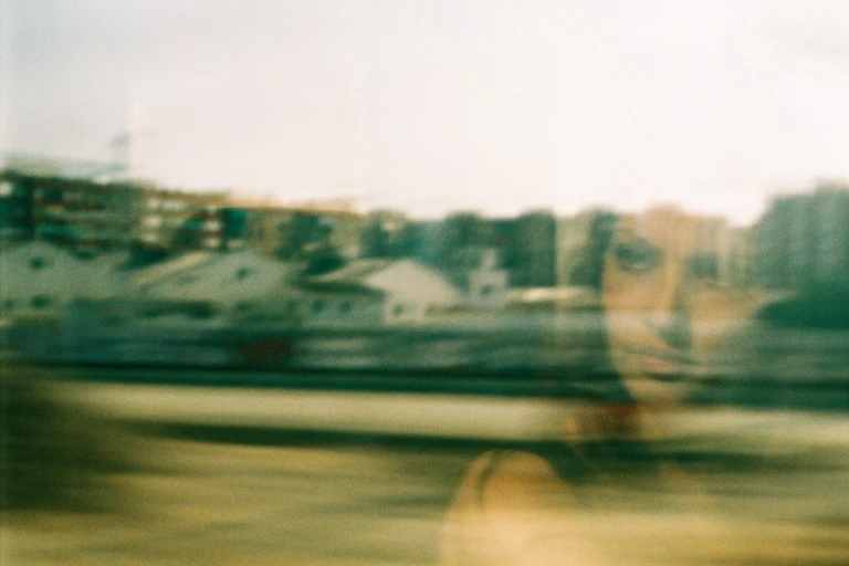 A woman gazes out a window with an envious look on her face.