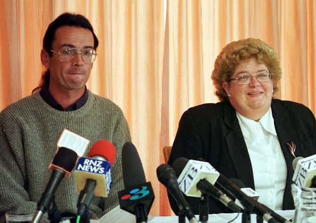 Man and woman lawyer with media microphones