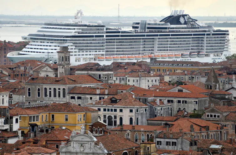 Cruise ship looms over city.