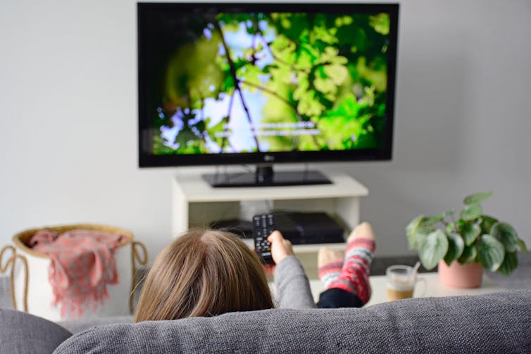 Young woman watching subtitled programme