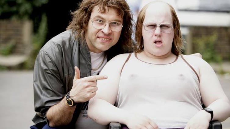 Actors David Walliams, pointing, and Matt Lucas, in a wheelchair.