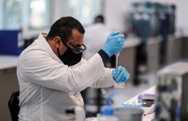 A scientist at the mAbxience's lab in Argentina using a pipette.