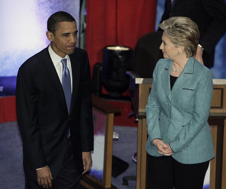 Barack Obama and Hillary Clinton stand next to each other