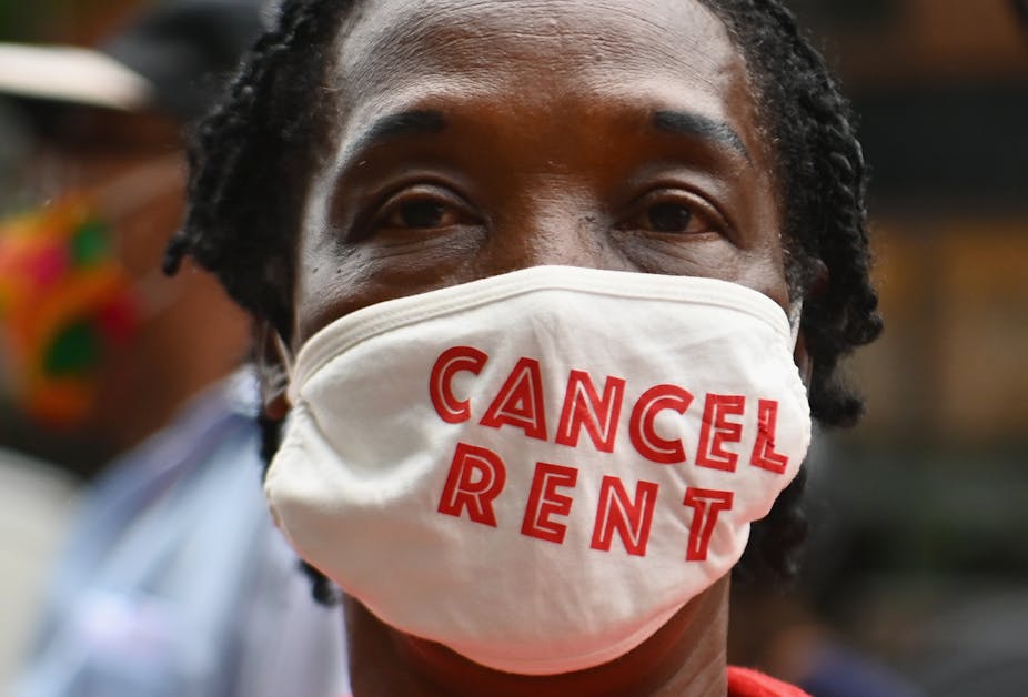 A woman wears a face mask that says "cancel rent."