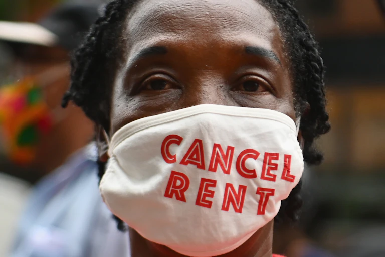 A woman wears a face mask that says "cancel rent."