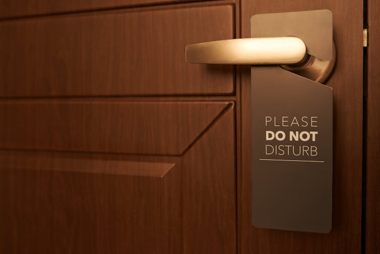 Closed door with 'Do Not Disturb' sign on door handle