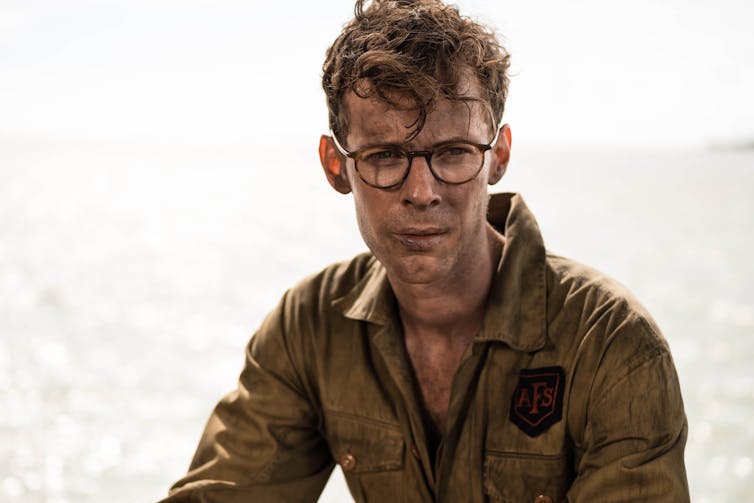 Young man with glasses, dirty uniform.